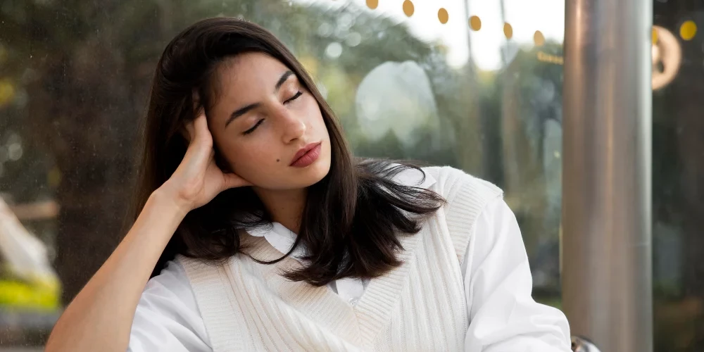 Woman sitting in relaxed posture with eyes closed